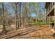 Lush backyard with trees, creek, and screened porch, perfect for enjoying nature at 210 Chiswick Close, Johns Creek, GA 30022