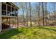 Serene backyard view featuring mature trees and a screened porch and patio at 210 Chiswick Close, Johns Creek, GA 30022