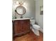 Charming powder room with a decorative vanity and a unique, round mirror at 210 Chiswick Close, Johns Creek, GA 30022