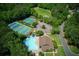 An aerial view shows a community with tennis courts, swimming pool, playground, and green space at 210 Chiswick Close, Johns Creek, GA 30022