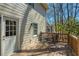 Home's deck featuring a table, chairs, and a view of the wooded backyard at 210 Chiswick Close, Johns Creek, GA 30022