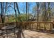Outdoor deck with a metal table and chairs, perfect for enjoying the wooded surroundings at 210 Chiswick Close, Johns Creek, GA 30022