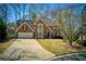 Charming brick home with manicured lawn and inviting curb appeal on sunny day at 210 Chiswick Close, Johns Creek, GA 30022