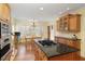 Eat in kitchen with stainless appliances, a granite island cooktop and a dining table with wooded views at 210 Chiswick Close, Johns Creek, GA 30022