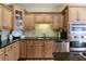 Renovated kitchen with modern stainless steel appliances and granite countertops and natural wood cabinetry at 210 Chiswick Close, Johns Creek, GA 30022