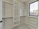 Spacious walk-in closet with custom shelving and ample storage, illuminated by natural light at 2329 Walker Dr, Lawrenceville, GA 30043