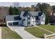 A modern home with a well-manicured front yard, a stone and siding facade, and an attached three-car garage at 2329 Walker Dr, Lawrenceville, GA 30043