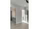 Hallway with white walls, light wood floors and view of the bathroom with sink and cabinet at 2329 Walker Dr, Lawrenceville, GA 30043