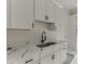 Laundry room with a stainless steel sink, white countertops, and shaker-style cabinets at 2329 Walker Dr, Lawrenceville, GA 30043