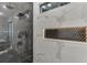 Close-up of a modern shower with black and marble tile, rainfall shower head, and a built-in niche at 2329 Walker Dr, Lawrenceville, GA 30043