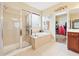 Spa-like bathroom with a glass shower, soaking tub, and beige tile surround at 1527 Sage Ridge Dr, Marietta, GA 30064