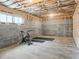 Unfinished basement with exposed ceiling and cinder block walls, featuring exercise equipment at 5728 Williams Rd, Norcross, GA 30093
