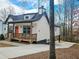 Quaint two-story home with a wooden deck, bright orange door, and driveway at 5728 Williams Rd, Norcross, GA 30093