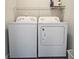 Functional laundry room featuring a side by side washer and dryer and convenient overhead storage at 5728 Williams Rd, Norcross, GA 30093