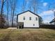 A modern home with white siding, dark trim, and a unique carport, set against a grassy landscape at 5728 Williams Rd, Norcross, GA 30093