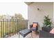 A balcony area featuring two wicker chairs, a small table, black iron railings, and a nice view at 970 Sidney Marcus Blvd # 1217, Atlanta, GA 30324