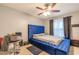 This cozy bedroom features a unique blue tufted bed, ceiling fan, and neutral decor, creating a peaceful retreat at 970 Sidney Marcus Blvd # 1217, Atlanta, GA 30324