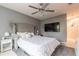 A modern bedroom featuring a tufted headboard, a ceiling fan with a chandelier, and gray walls at 970 Sidney Marcus Blvd # 1217, Atlanta, GA 30324