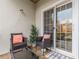 An outdoor patio area featuring two wicker chairs, a small table, and sliding glass doors at 970 Sidney Marcus Blvd # 1217, Atlanta, GA 30324