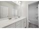 Bright bathroom with a double sink vanity with white cabinets and a door leading to the shower and toilet at 1566 Winding Ridge Trl, Hoschton, GA 30548
