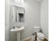 Clean powder room with pedestal sink, toilet, and modern fixtures at 1566 Winding Ridge Trl, Hoschton, GA 30548