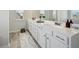 Bright bathroom featuring a long vanity with white cabinets and plenty of counter space at 1566 Winding Ridge Trl, Hoschton, GA 30548