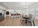 Open-concept kitchen with stainless appliances, large island, and dining area with natural light at 1566 Winding Ridge Trl, Hoschton, GA 30548