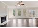 Bright living room featuring a fireplace, hardwood floors, ceiling fan, and double doors at 3946 Lockaby Way, Lawrenceville, GA 30044