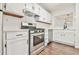 Bright kitchen featuring stainless steel appliances, white cabinetry, dark hardware, and a view to the dining area at 808 Riverview Se Dr, Marietta, GA 30067