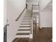 Bright foyer with hardwood floors and staircase leading to the second level with decorative railing at 1871 Lacebark Elm Way, Lawrenceville, GA 30045