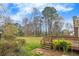Expansive backyard with lush greenery, mature trees, and a wooden deck at 532 Rivercrest Dr, Woodstock, GA 30188