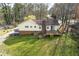 Exterior rear view featuring a well-maintained lawn, mature trees, and a house with a deck and chimney at 532 Rivercrest Dr, Woodstock, GA 30188