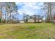 Spacious backyard with a large grassy area and mature trees at 532 Rivercrest Dr, Woodstock, GA 30188