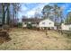 Quaint yellow home on a well-manicured lawn, surrounded by lush trees in a quiet neighborhood at 532 Rivercrest Dr, Woodstock, GA 30188