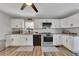 Well-lit kitchen offers white cabinets, granite counters, and modern stainless steel appliances at 532 Rivercrest Dr, Woodstock, GA 30188