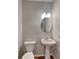 Updated half bathroom features a pedestal sink and a round mirror at 634 Sandpiper Cv, Stockbridge, GA 30281