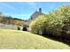 Backyard with manicured lawn, white picket fence, and colorful bushes enhancing the property's appeal at 1002 River Plantation Drive, Woodstock, GA 30188
