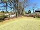 Large backyard with a wooden fence, mature trees, and well-maintained lawn at 1002 River Plantation Drive, Woodstock, GA 30188