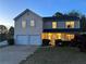 Inviting two-story home with a well-maintained lawn, a two-car garage, and charming blue shutters at 1002 River Plantation Drive, Woodstock, GA 30188