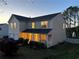 Charming two-story home with a covered front porch, well-manicured lawn, and inviting curb appeal at dusk at 1002 River Plantation Drive, Woodstock, GA 30188
