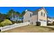 Side view of two-story home with white picket fence and two-car garage at 1002 River Plantation Drive, Woodstock, GA 30188