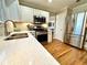Updated kitchen with white cabinets, stainless steel appliances, and quartz countertops at 1002 River Plantation Drive, Woodstock, GA 30188