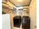 Bright laundry room features front loading washer and dryer with overhead storage shelves at 1002 River Plantation Drive, Woodstock, GA 30188