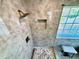 Shower featuring a rainfall shower head, pebble tile floor and window at 1002 River Plantation Drive, Woodstock, GA 30188
