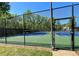 Community tennis court with a well-maintained green and blue surface, surrounded by a secure fence at 1002 River Plantation Drive, Woodstock, GA 30188