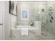 Bright bathroom with a soaking tub, gray marble tiling, a window, and a separate glass shower at 3139 Hilltop Dr, Marietta, GA 30066