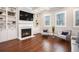 Comfortable living room with a fireplace, custom built-ins, hardwood floors, and large windows at 3139 Hilltop Dr, Marietta, GA 30066