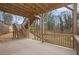 A covered patio features wood beams, concrete floors, and a wooden railing overlooking the landscaped backyard at 3139 Hilltop Dr, Marietta, GA 30066