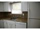 Functional kitchen with white cabinets, brown backsplash, and a stainless steel sink for easy cleanup at 3338 York Pl, Decatur, GA 30032