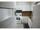 Galley kitchen boasts white cabinets and appliances, including the range, and countertop with eat-in bar space at 3338 York Pl, Decatur, GA 30032